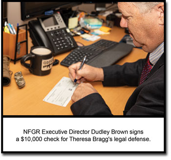 NFGR Executive Director Dudley Brown signs a check for Theresa Bragg's legal defense.
